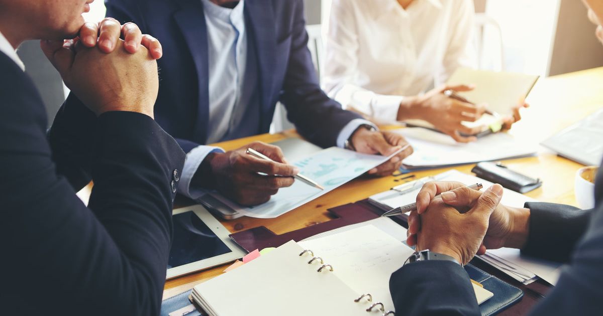 Business meeting with documents and devices on table.