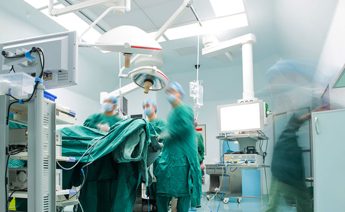 Surgeons operating in a modern hospital room.