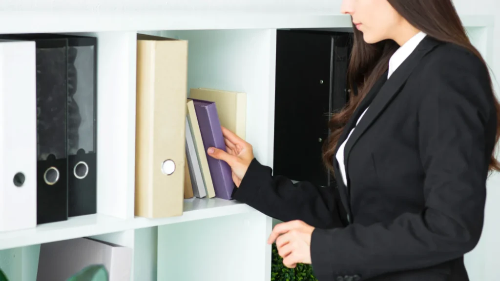 Woman in suit arranging files on shelf