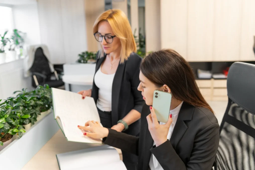 Two businesswomen discussing a document in office.