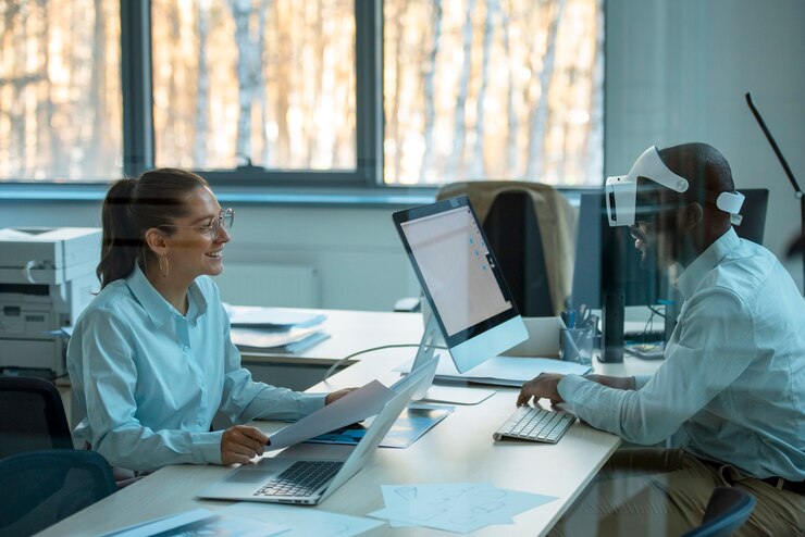 Two colleagues working at computers in an office.