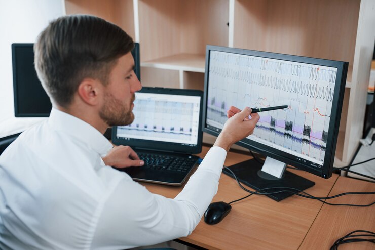 Analyst examines data on multiple monitors.