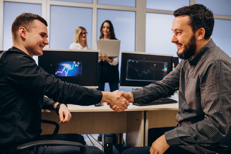 Two men shaking hands in office.